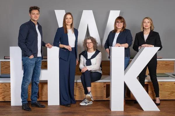 Businessfotografie kreatives Gruppenbild mit Logo im Büro Köln fünf Personen Firmenportrait