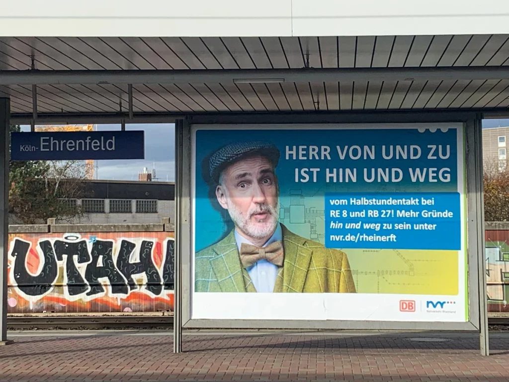Großflächenplakat mit Männerportrait am Bahnhof Köln-Ehrenfeld – Kampagne für den Nahverkehr Rheinland, fotografiert von nonverbal | businessfotografie.