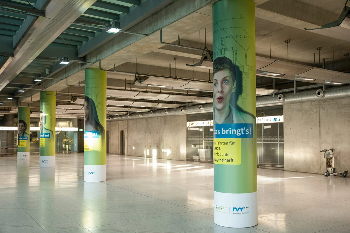 Werbesäulen am Flughafen Köln/Bonn mit Motiven der Nahverkehr Rheinland Kampagne – fotografiert für nonverbal | businessfotografie.
